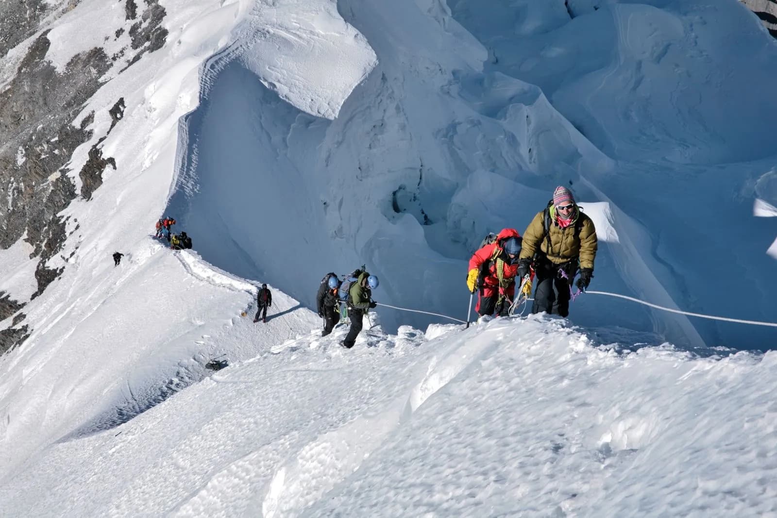 Climbers ascending a snow ridge in the Himalayas